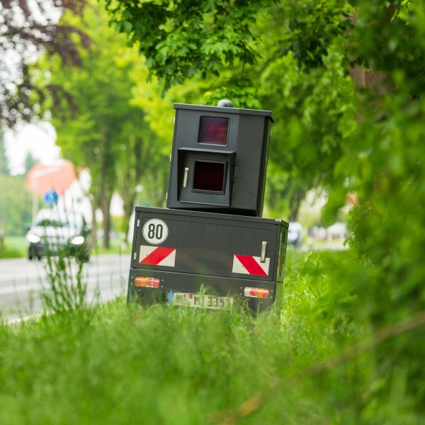 blitzer steht am straßenrand im grünen