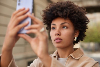 frau fotografiert sich selbst mit dem handy