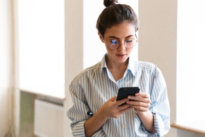 frau schaut auf ihr handy