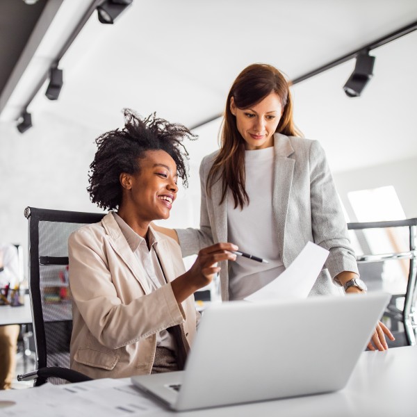 zwei frauen unterhalten sich im büro über ein dokument