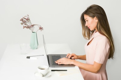 frau sitzt am schreibtisch vor dem laptop