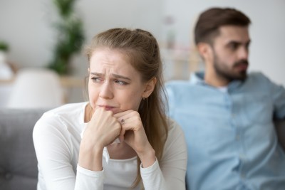 frau sitzt weinend mit tascchentuch in der hand neben dem mann