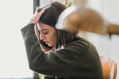 frau mit handy fasst sich an den kopf