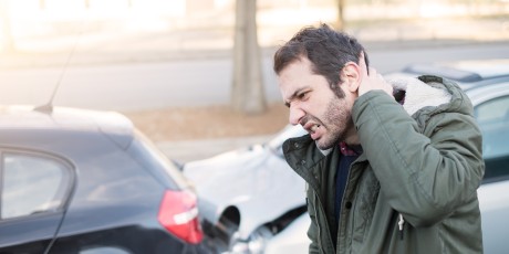 mann greift sich an den nacken nach einem autounfall