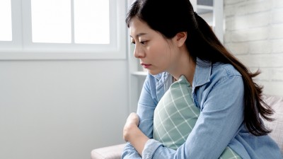 Frau sitzt traurig im Zimmer