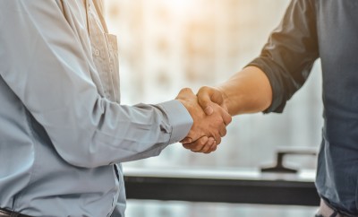 Zwei Personen geben sich einen Handschlag