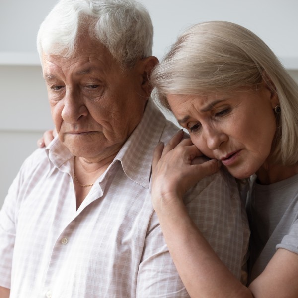 Mann und Frau sitzen traurig zusammen
