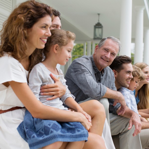 Familie sitzt vor ihrem Haus