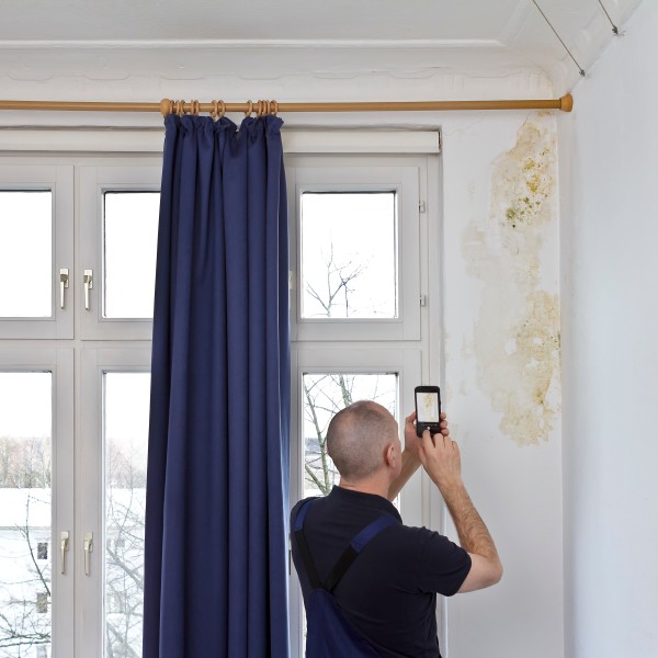 Mann macht Foto von Schimmel mit Handy