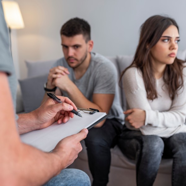 Paar sitzt auf dem Sofa voneinander abgewendet