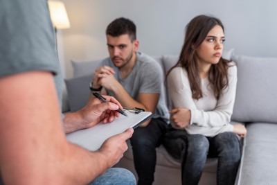 Paar sitzt auf dem Sofa voneinander abgewendet