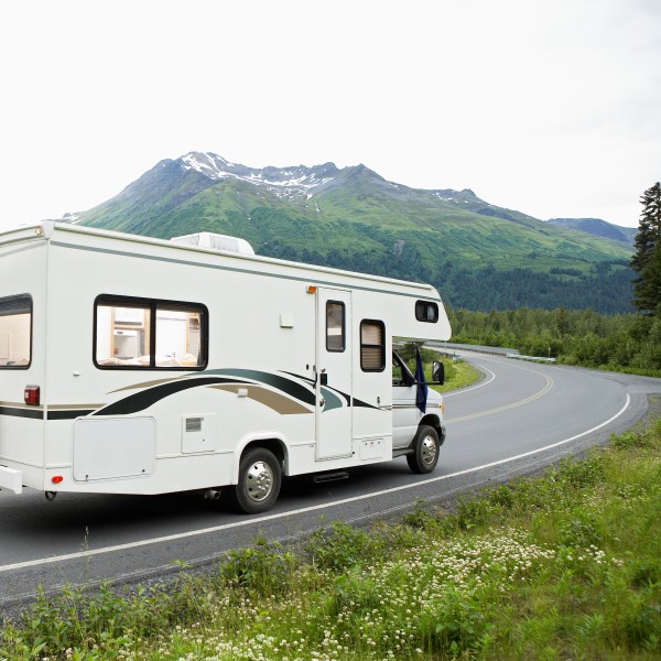 wohnmobil fährt auf einer straße in den alpen