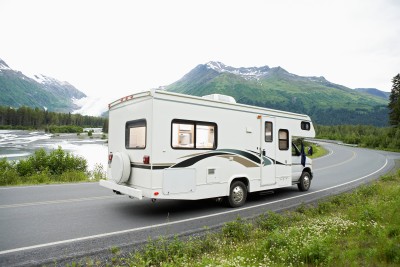 wohnmobil fährt auf einer straße in den alpen