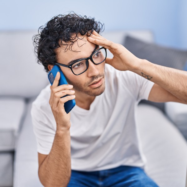 Mann schaut nachdenklich am Telefon